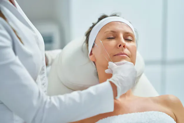 صورة توضح دكتور ستقوم بتطبيق طريقة من طرق علاج ترهل الوجه في سن الأربعين